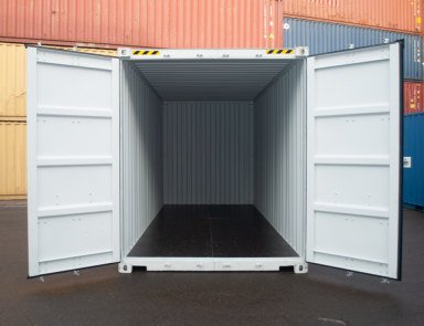 White shipping container with both doors open, showing the white interior and dark wood floor